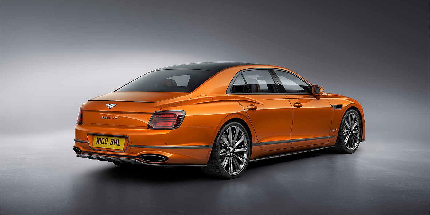 Bentley Zug Bentley Flying Spur Speed in Orange Flame colour rear view, featuring Bentley insignia and enhanced exhaust muffler.