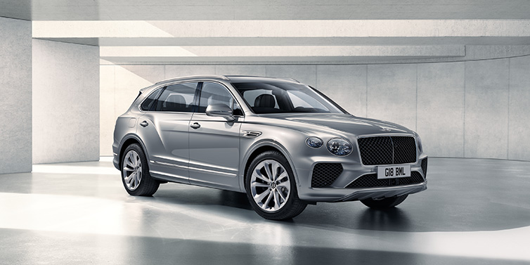 Bentley Zug Bentley Bentayga Extended Wheelbase SUV front three quarter in Moonbeam paint with a grey background