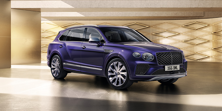 Bentley Zug Bentley Bentayga Extended Wheelbase Mulliner SUV front three quarter in Tanzanite Purple paint with a gold patterned background