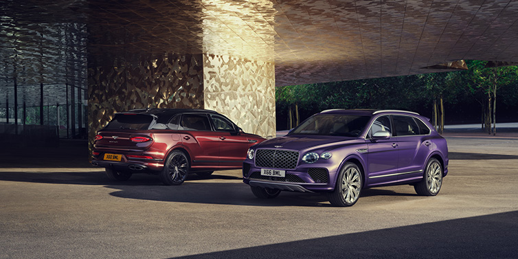 Bentley Zug A duo of Bentley Bentayga Extended Wheelbase Mulliner SUVs parked in a city environment, with Tanzanite Purple and Cricket Ball red exterior paint