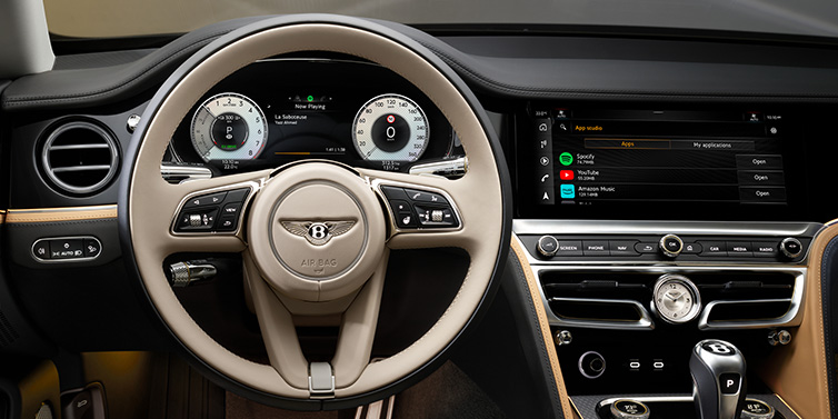 Bentley Zug Bentley Flying Spur Mulliner sedan front interior detail of steering wheel and driver screens surrounded by Linen and Beluga black hides