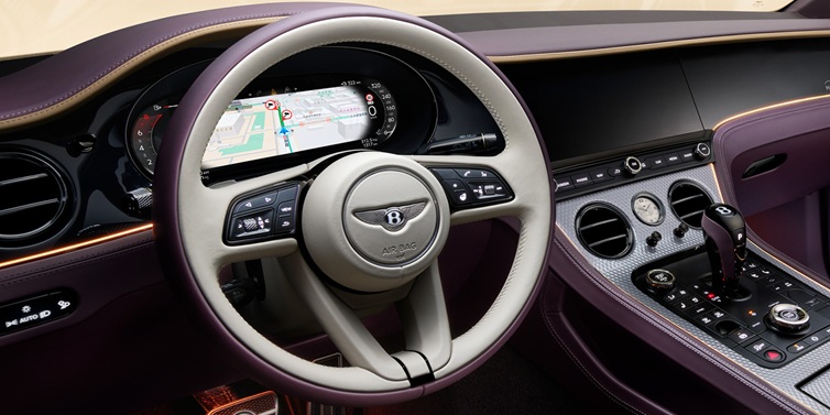 Bentley Zug Bentley Continental GT Mulliner coupe front interior showing steering wheel and drivers screens surrounded by Linen and Damson hides and Grand Black veneer